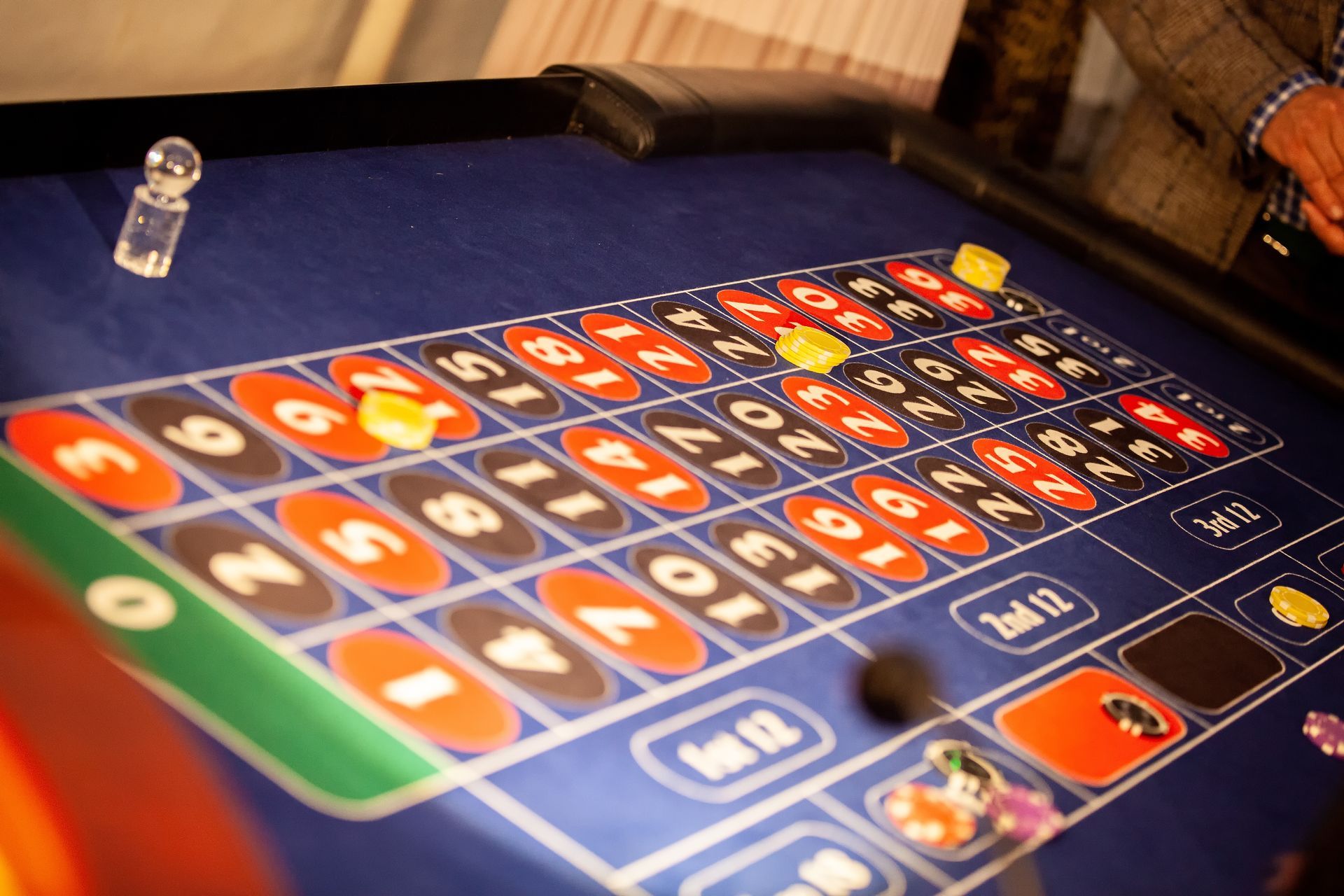 Roulette table with chips and ball in motion; focus on the numbered betting grid.