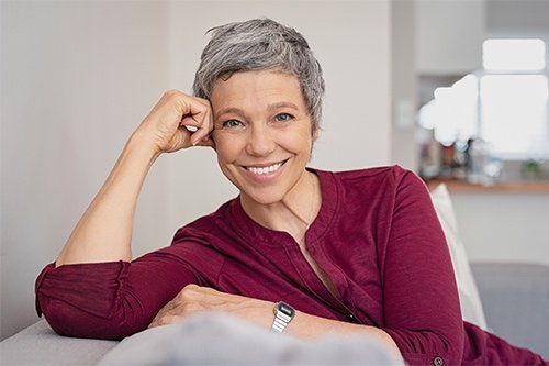Happy Senior Woman Sitting On Couch