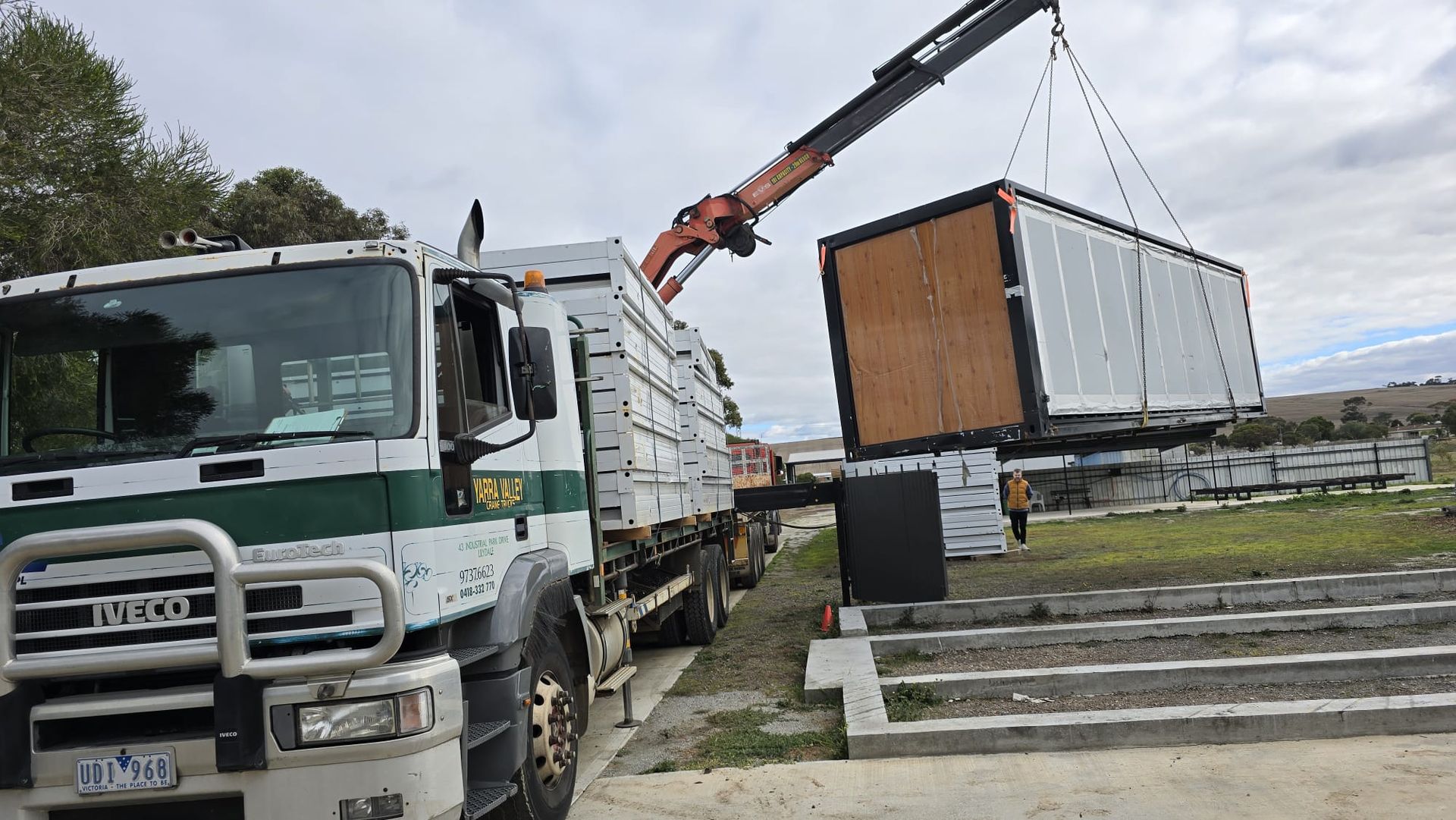A truck is carrying a container with a crane attached to it.