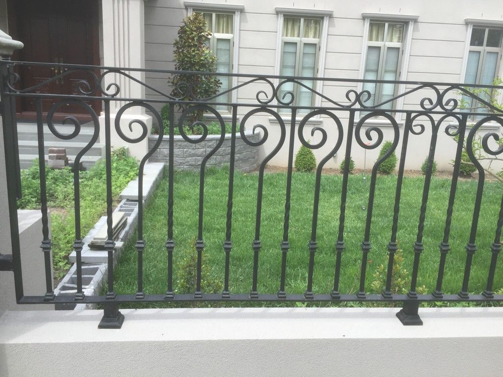 A wrought iron fence is in front of a house