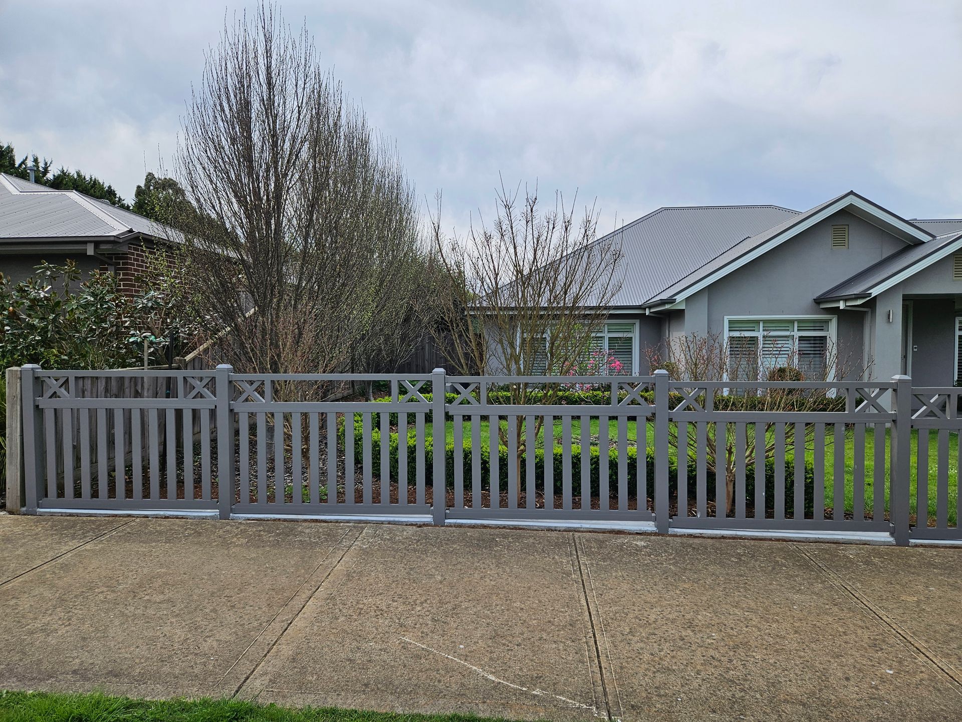 A house with a fence and a gate in front of it.