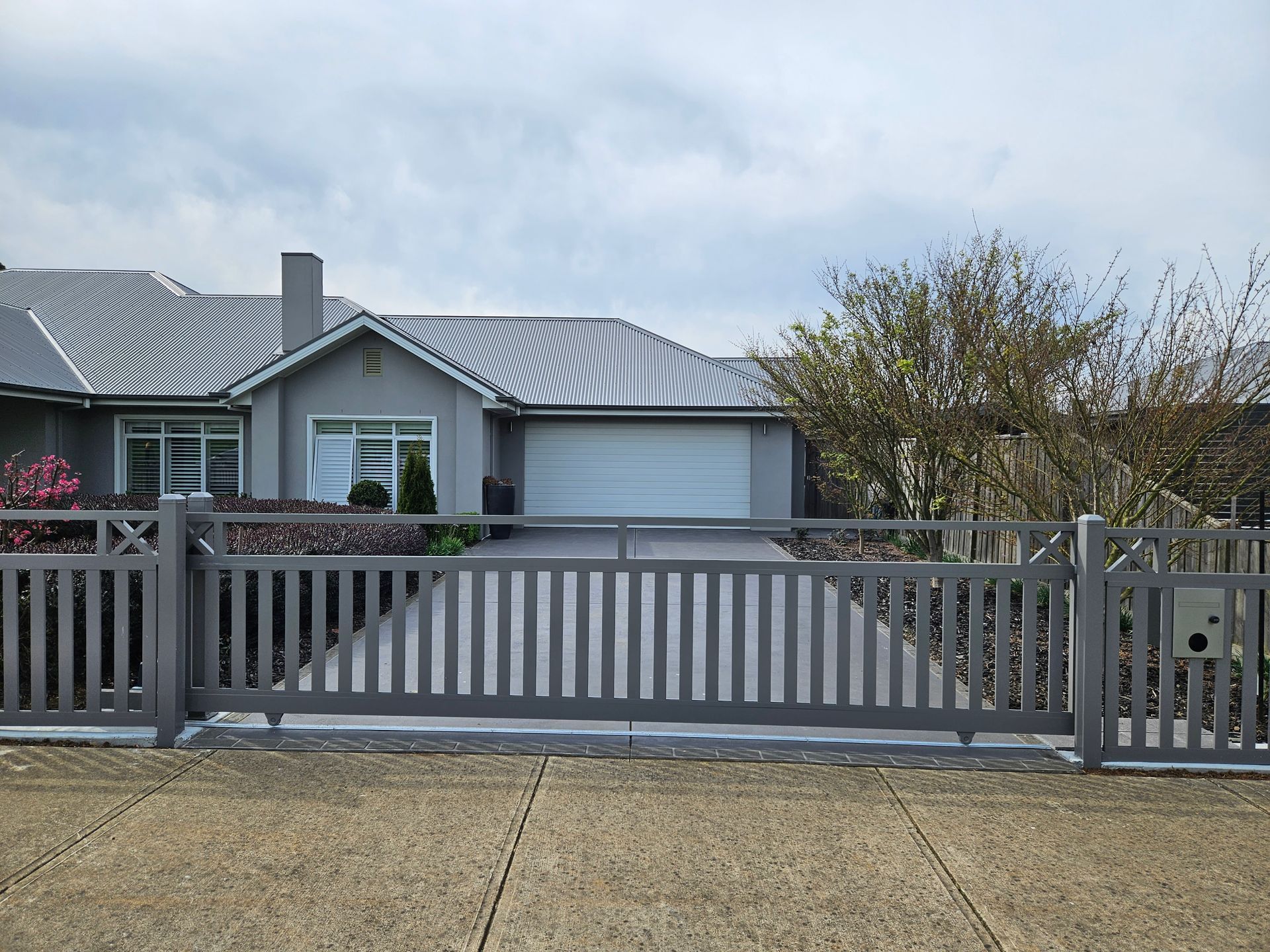 A house with a sliding gate in front of it