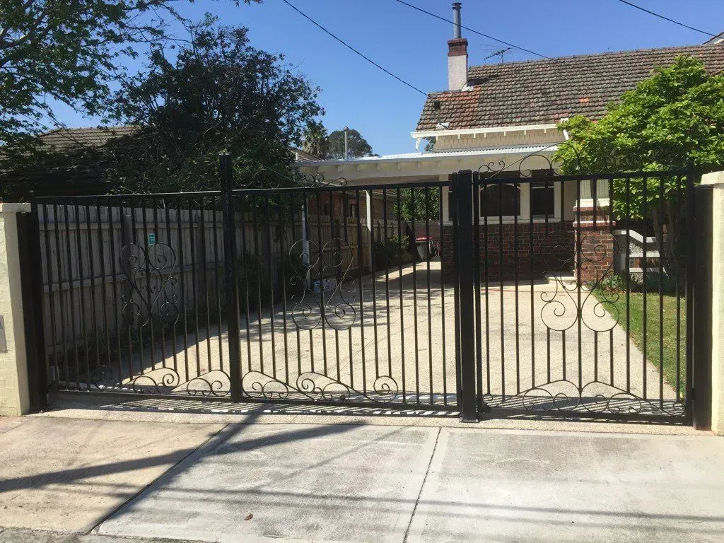 A brick house with a black gate in front of it