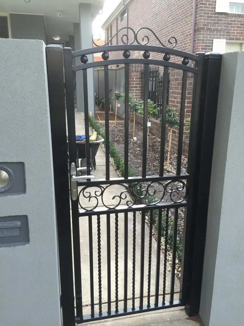 A wrought iron gate leading to a brick building