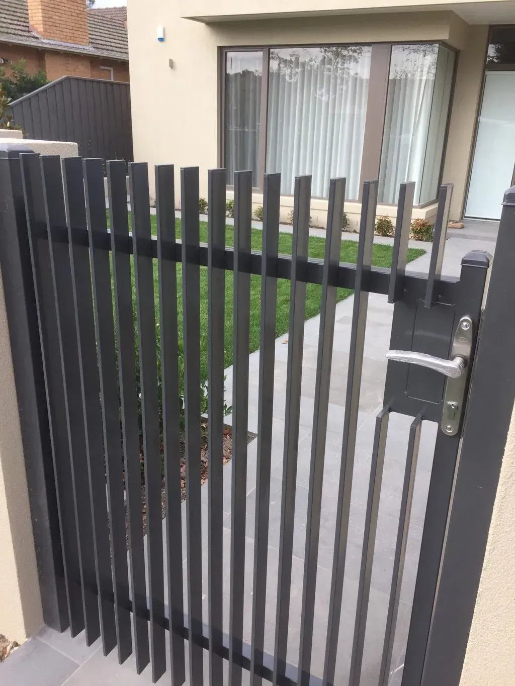 A fence with a gate in front of a house.