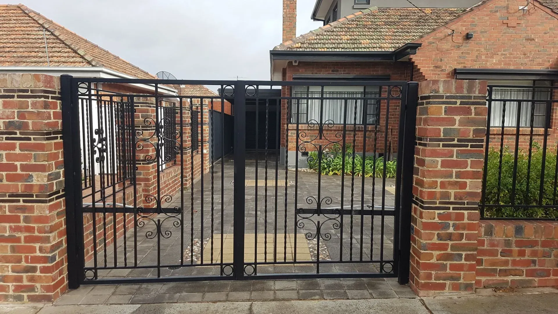 A brick building with a black gate in front of it