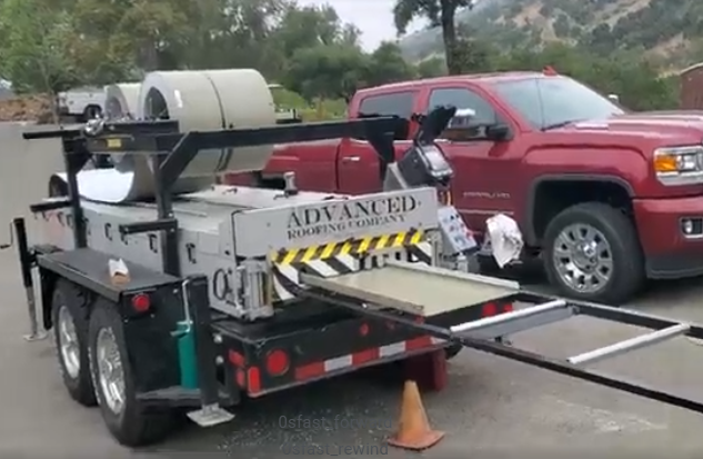 A roofing material processing trailer with a red pickup truck parked next to it — Modern House Construction with Metal Roof in Napa, CA A roofing material processing trailer with a red pickup truck parked next to it — Modern House Construction with Metal Roof in Napa, CA