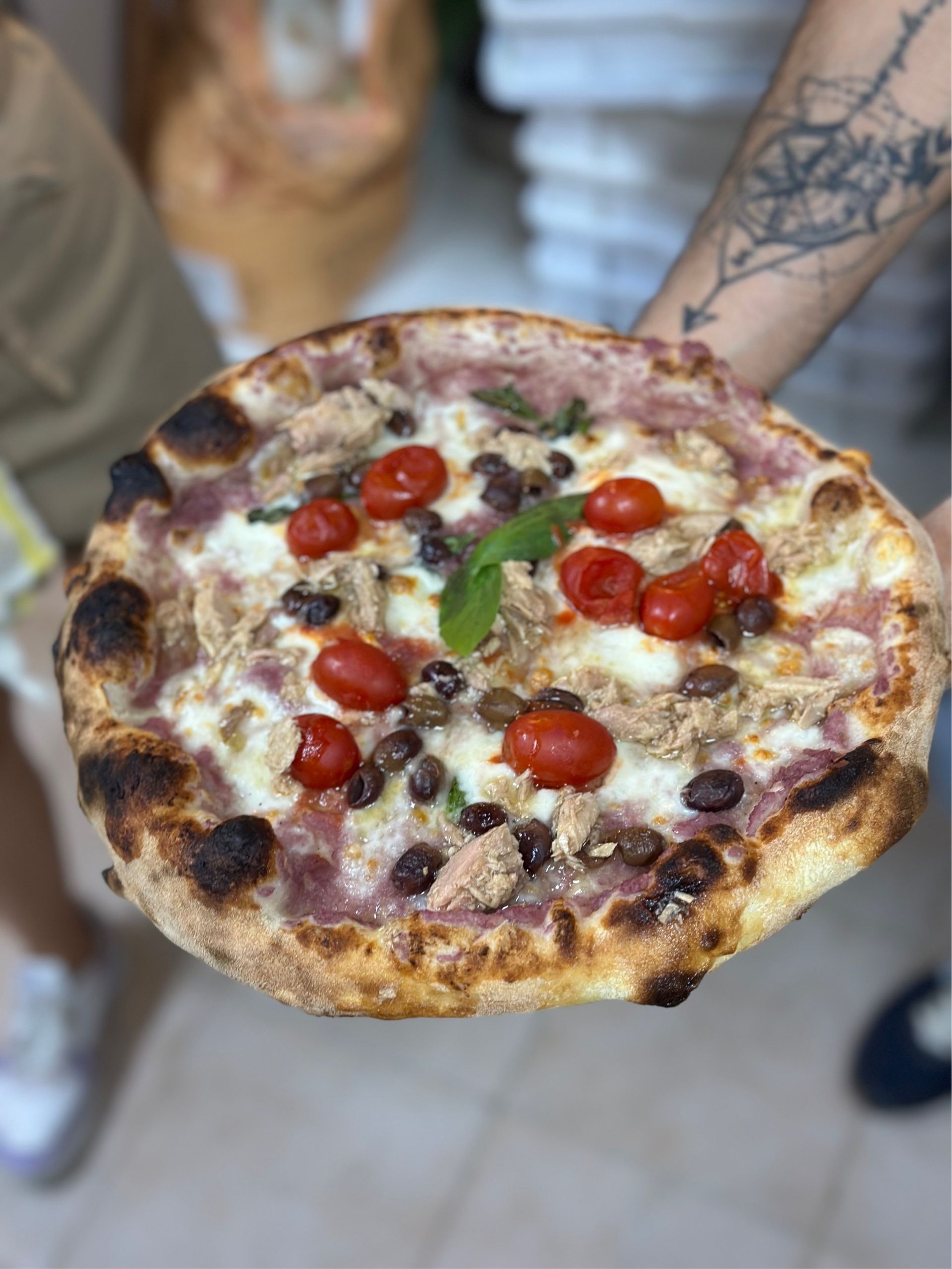 Tazzina di caff&egrave; espresso italiano su tavolo rustico con croissant, in atmosfera mattutina accogliente.