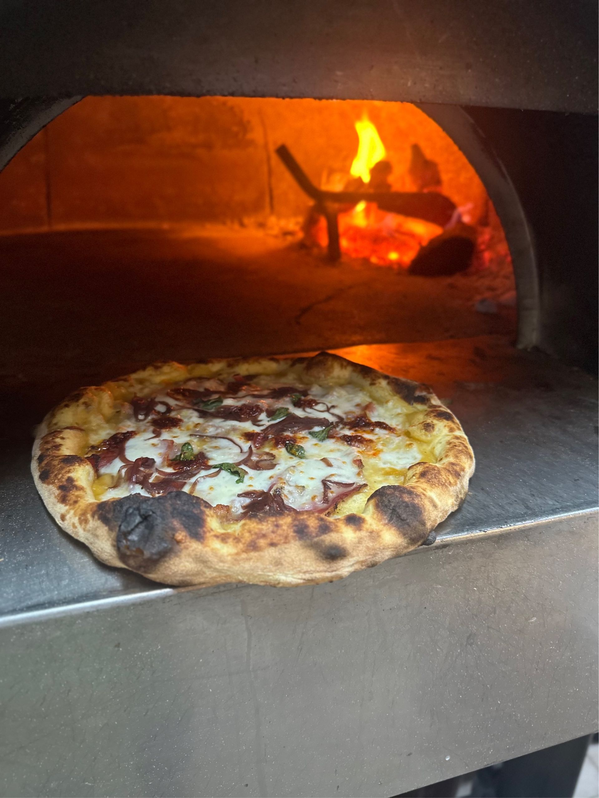 Tazzina di caff&egrave; espresso italiano su tavolo rustico con croissant, in atmosfera mattutina accogliente.