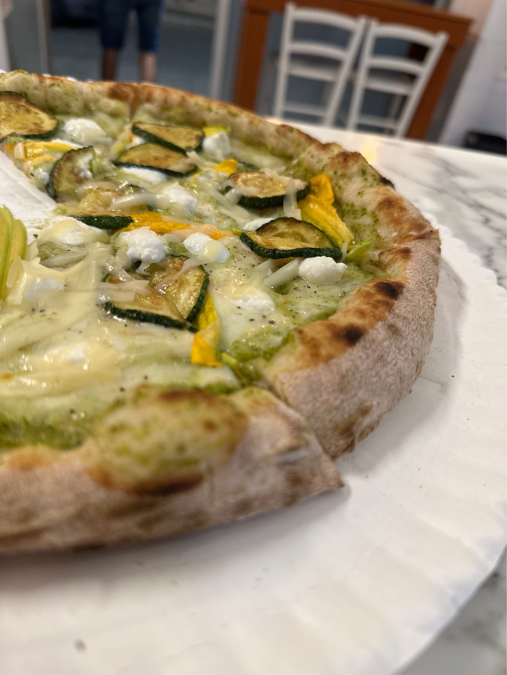 Interno di Lo Zar con il forno a legna acceso e l'atmosfera calda e accogliente della pizzeria.