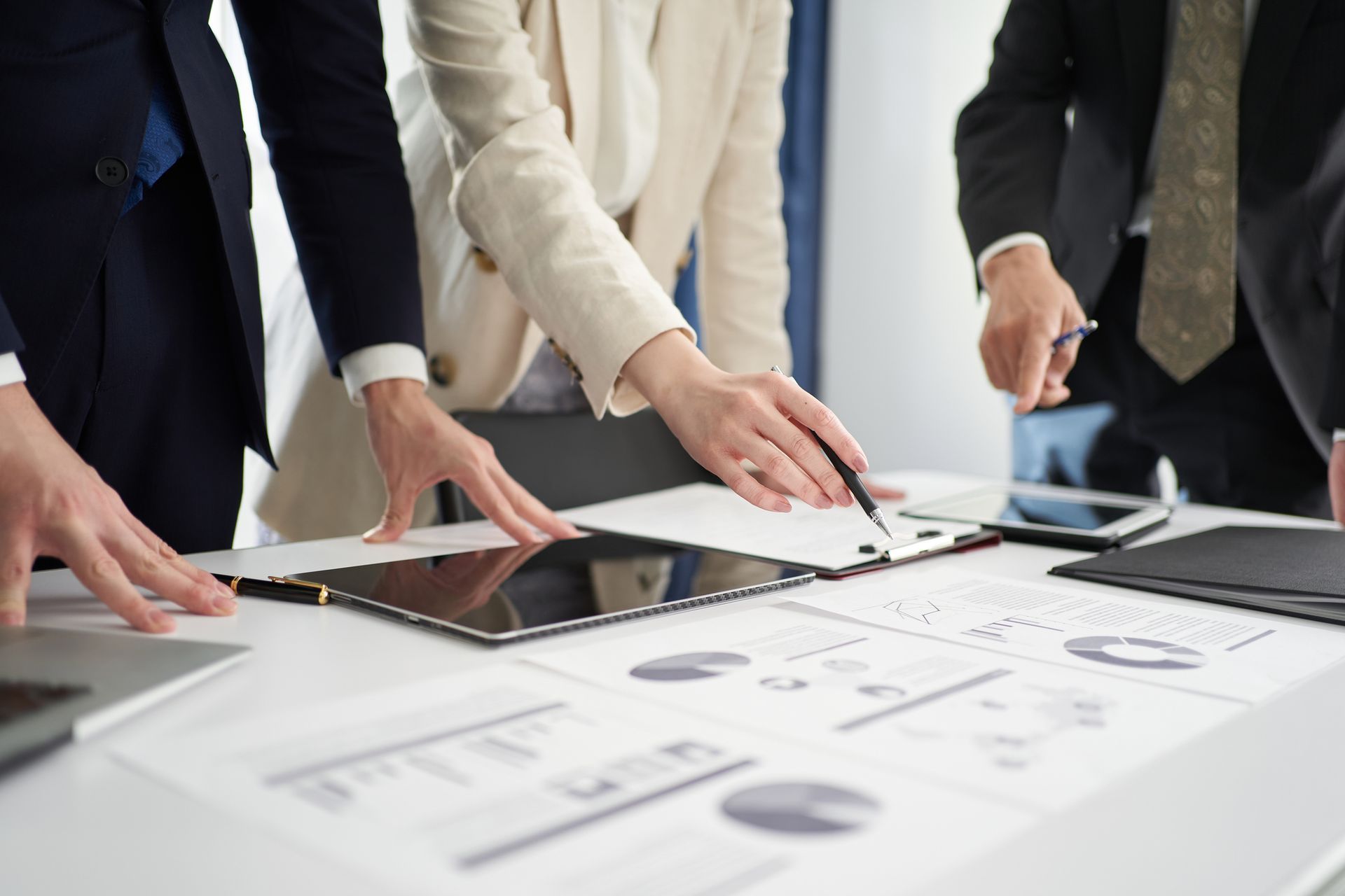 A group of business people are sitting around a table looking at charts.