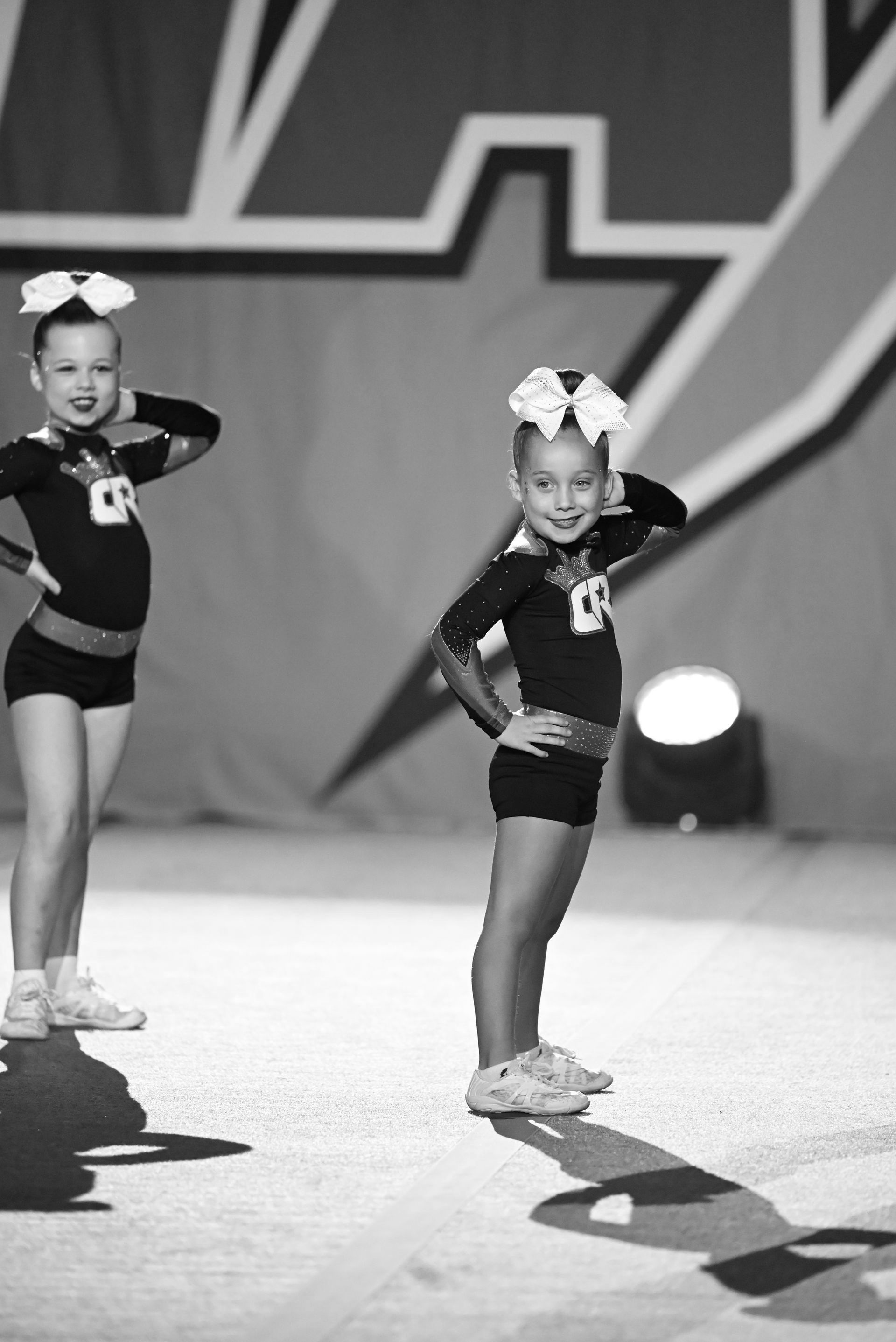 A black and white photo of two cheerleaders in front of a star