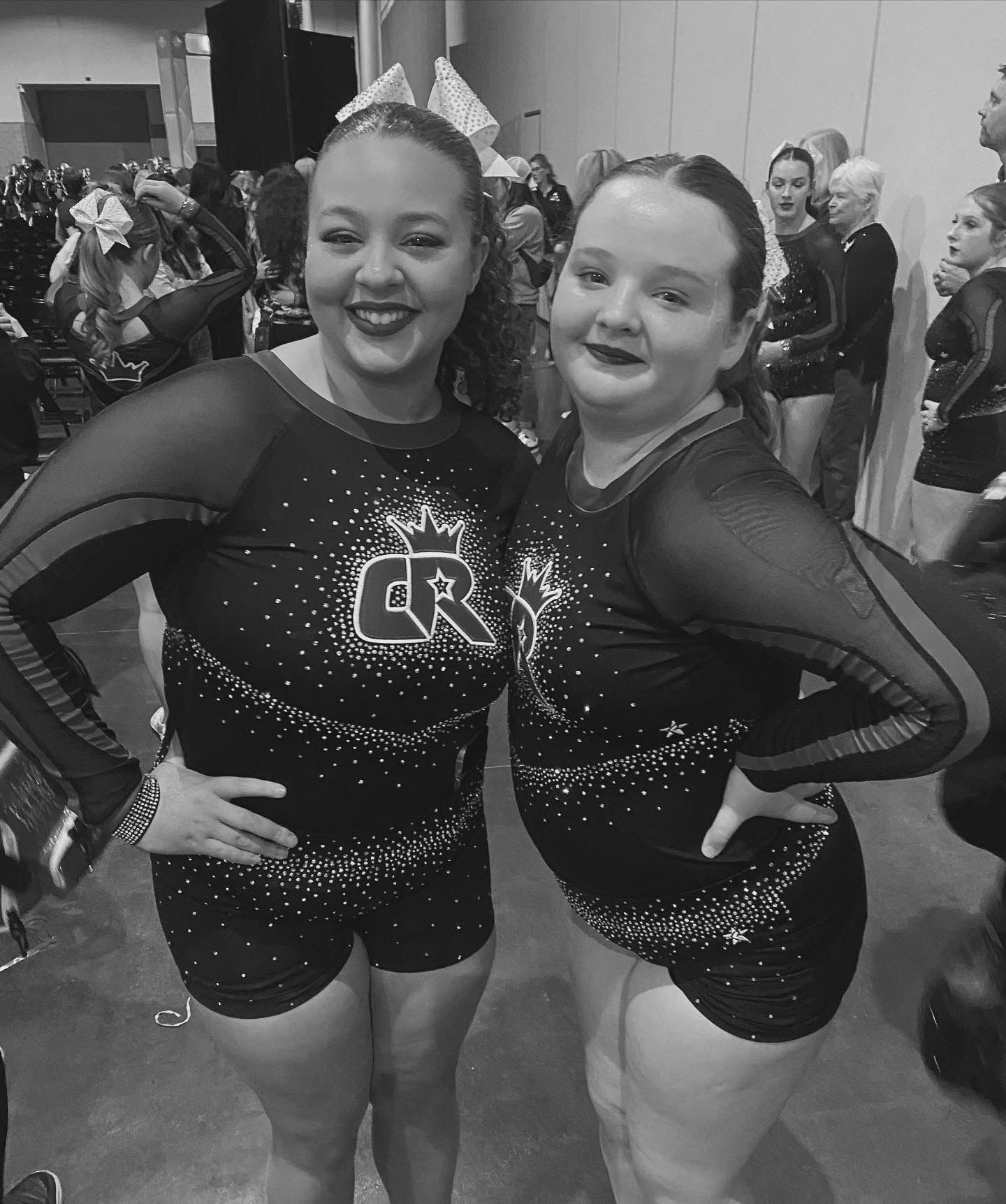 Two cheerleaders are posing for a black and white photo