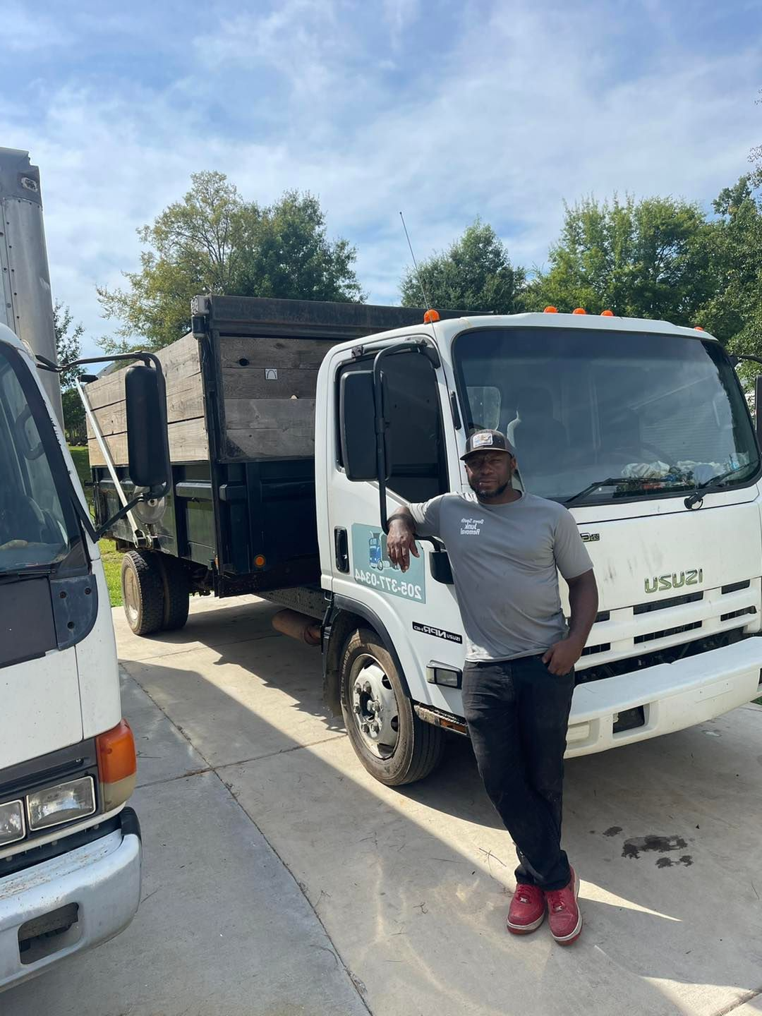 guy leaning on down south junk removal truck