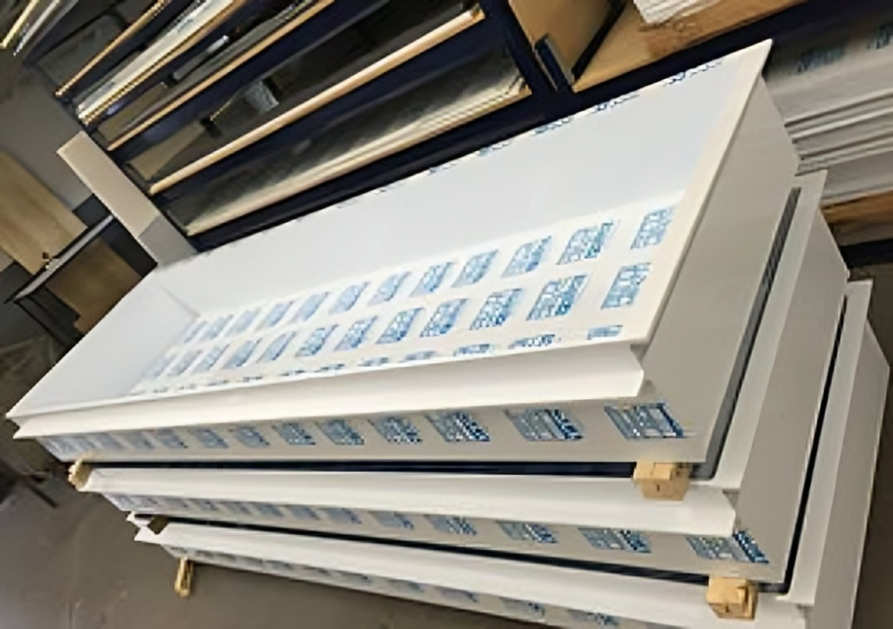 A stack of white acrylic sheets with blue letters on them