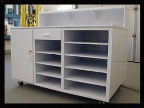 A white cabinet with shelves and a drawer on wheels.