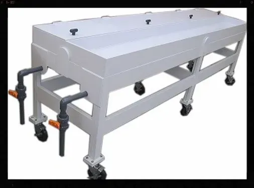 A white table with wheels and pipes attached to it