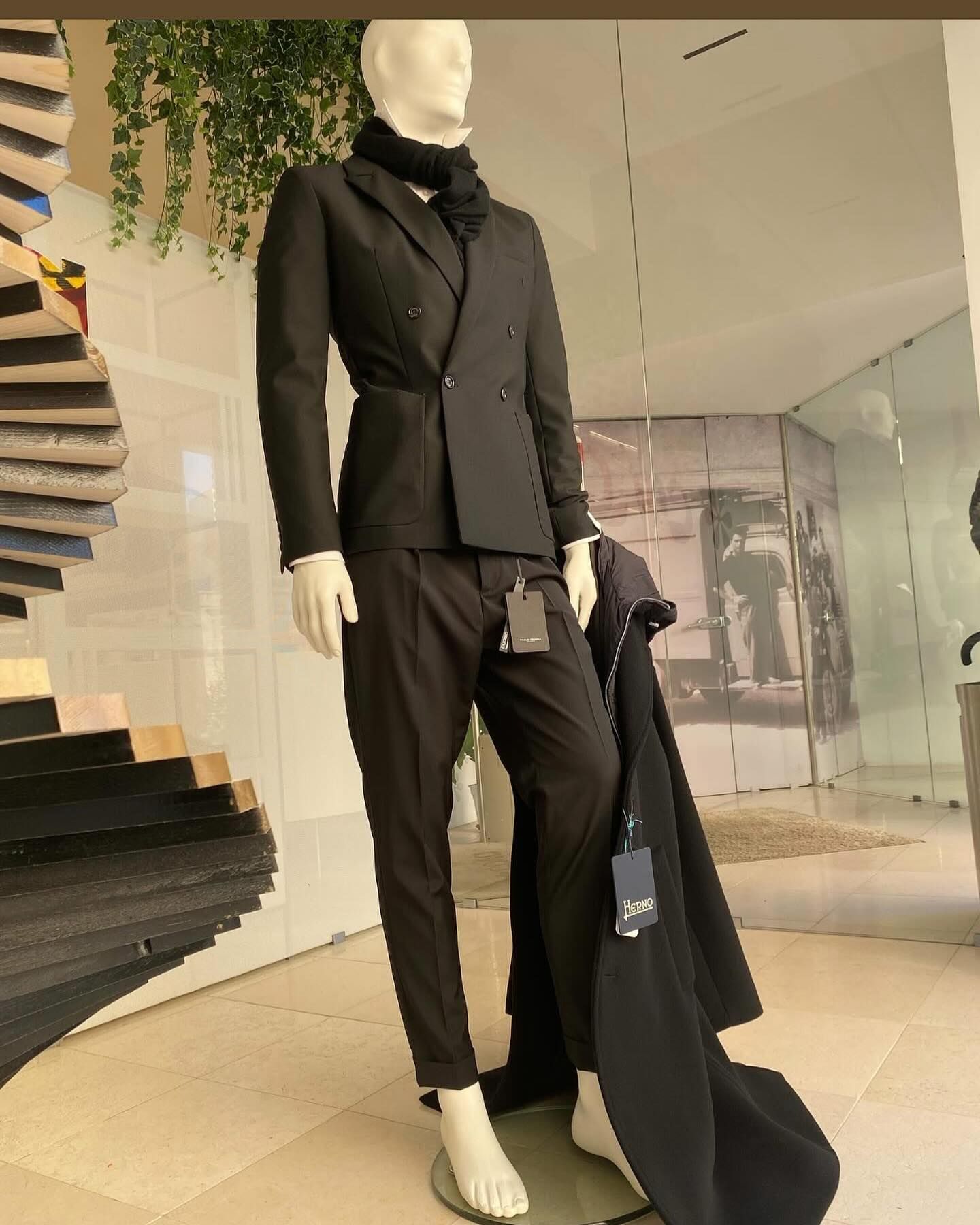 Manichino con lungo abito nero e pelliccia, esposto nella vetrina di un negozio.