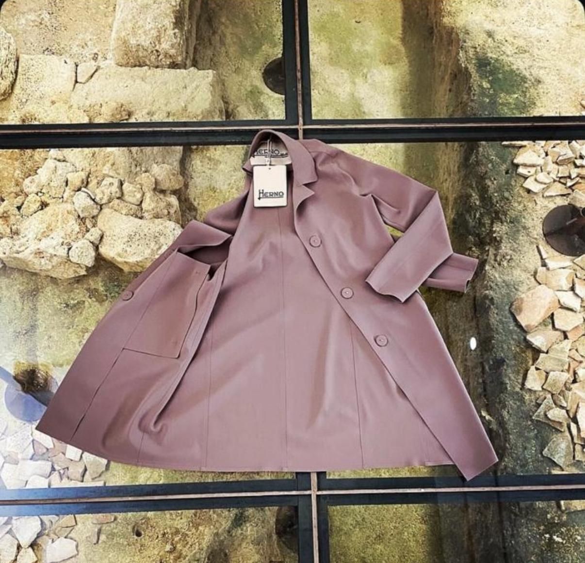 Vetrina con manichini in vari abiti marroni, tra cui un tailleur e degli abiti.