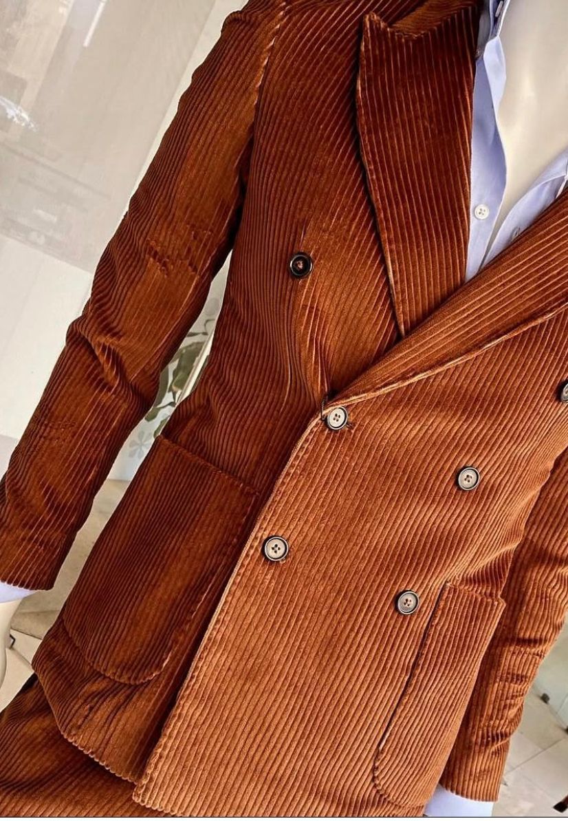 Un uomo con indosso un cappotto e un maglione con la scritta