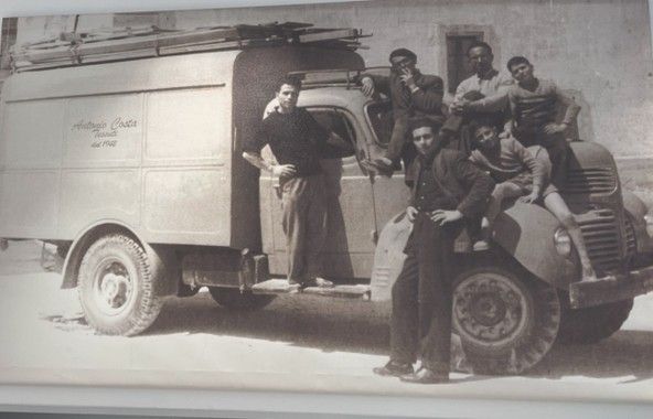Manichino con un lungo cappotto nero con cappuccio e cintura in vita.