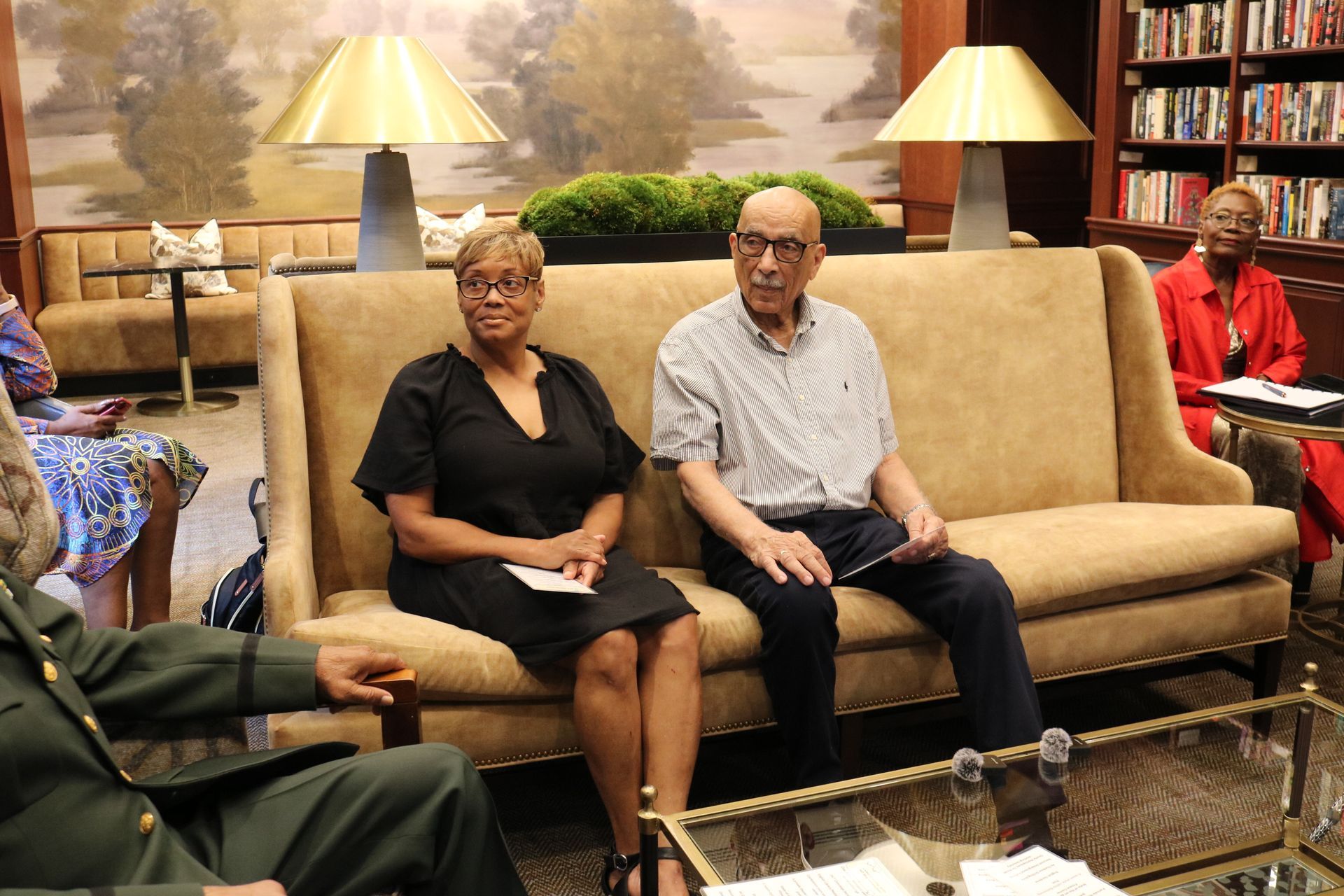 People seated on a sofa indoors, participating in a discussion.