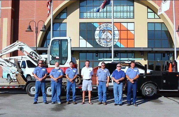 A group of plumbers standing in front of a building