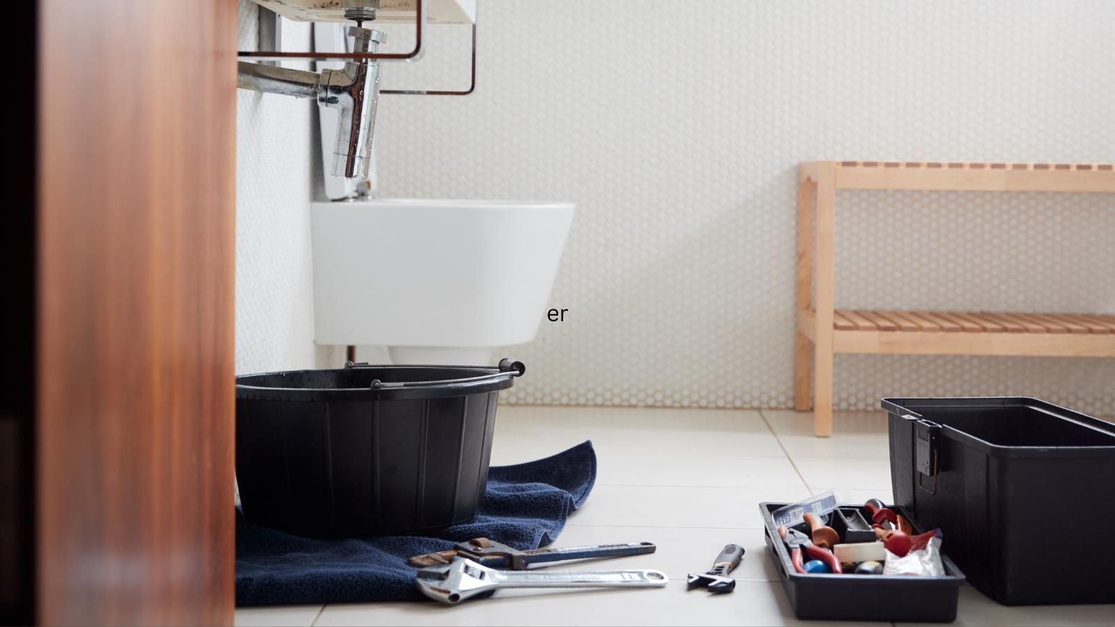 A bathroom with a sink and tools on the floor.