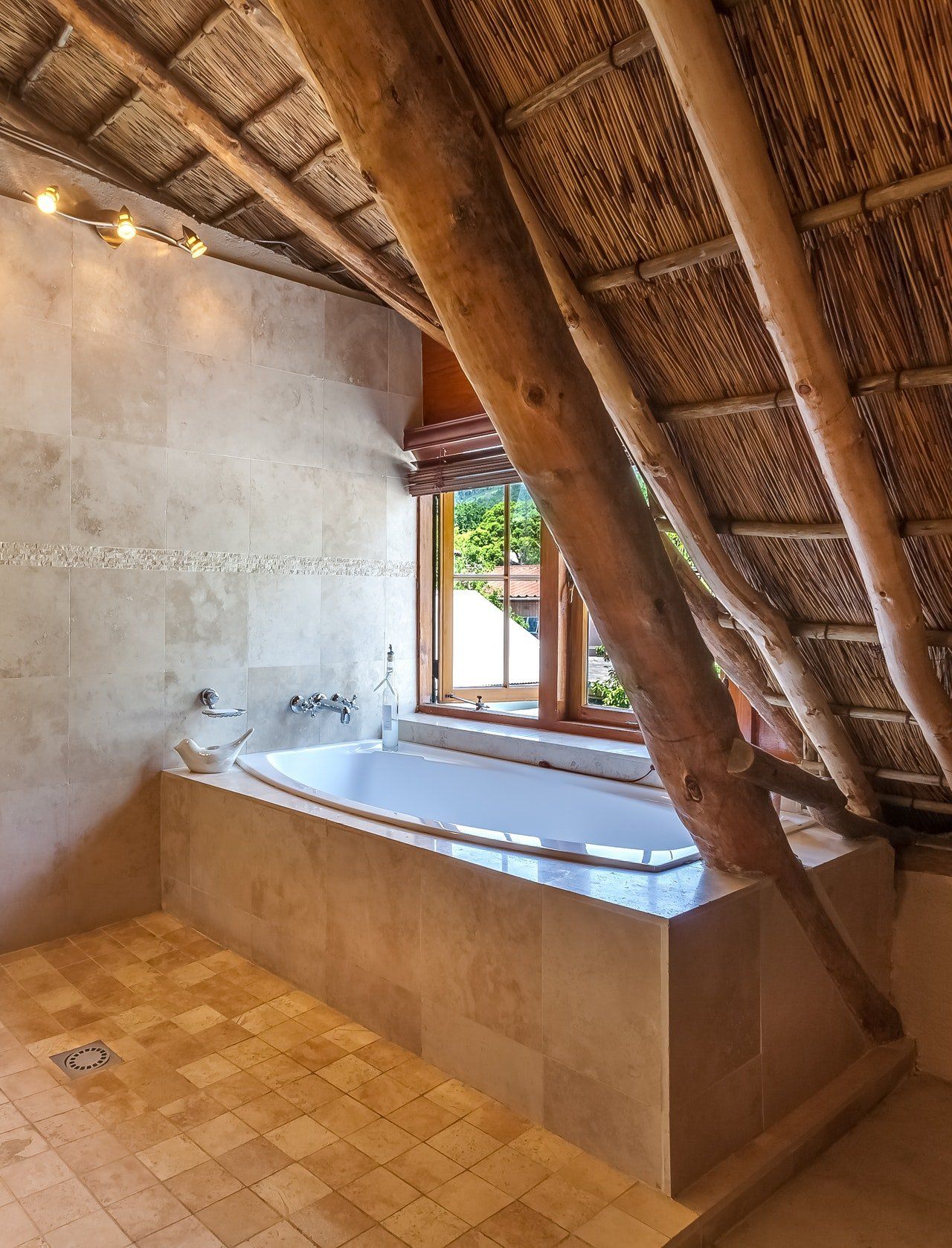 Exposed bamboo in a white stone bathroom