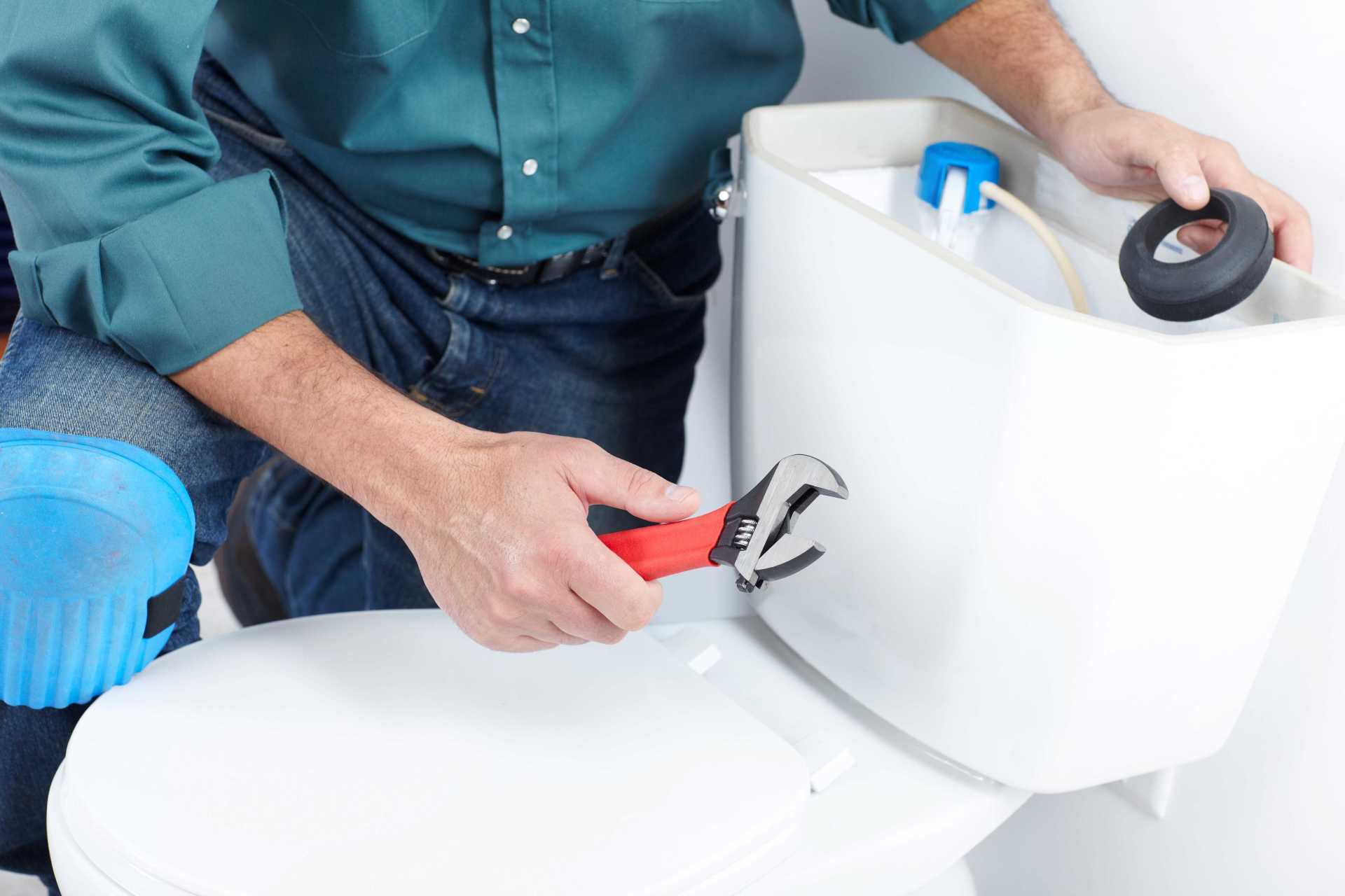 guy replacing piece on the back of a toilet