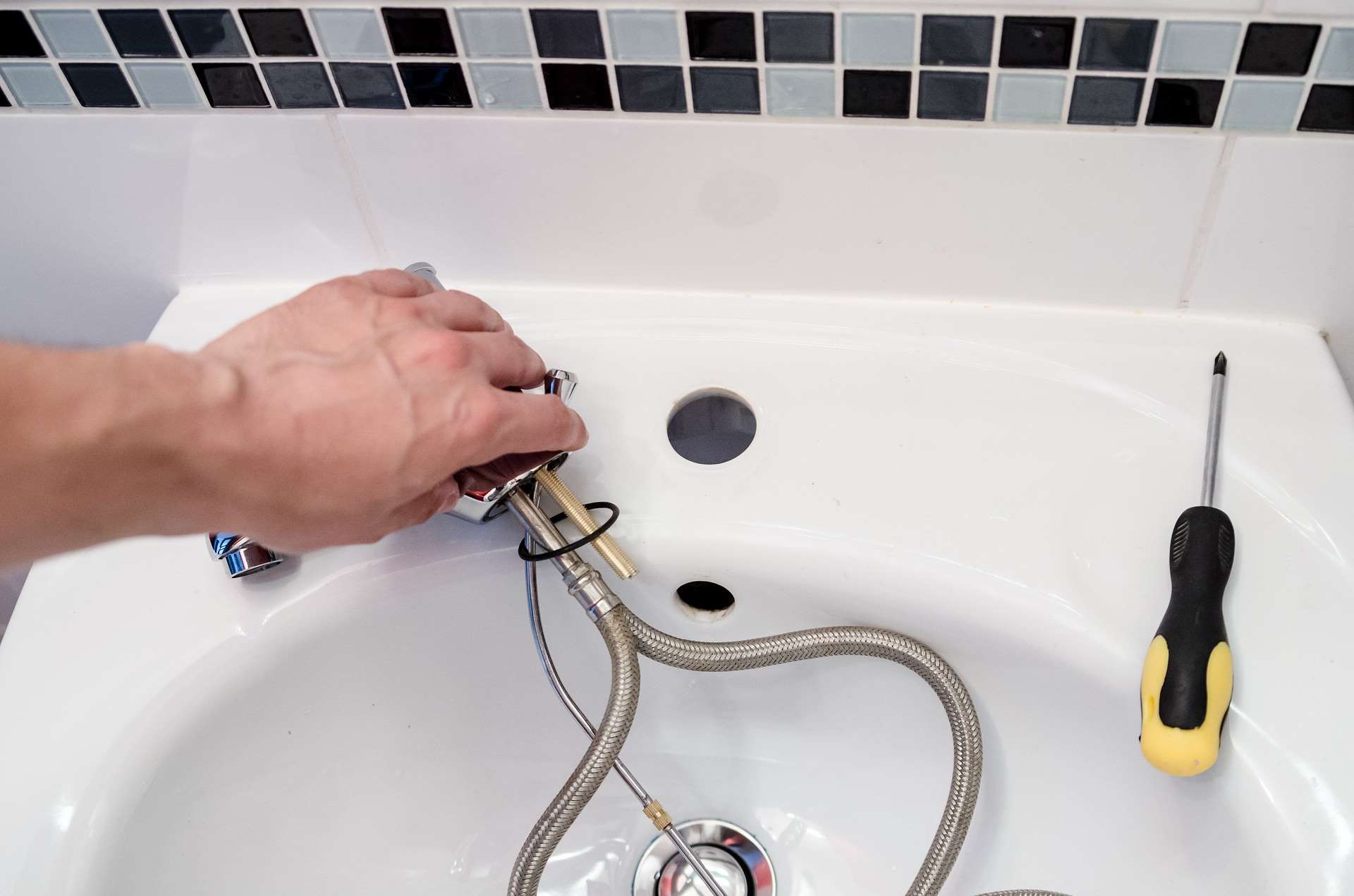 Person pulling sink components out