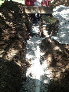 A pipe is being installed in a hole in the ground.