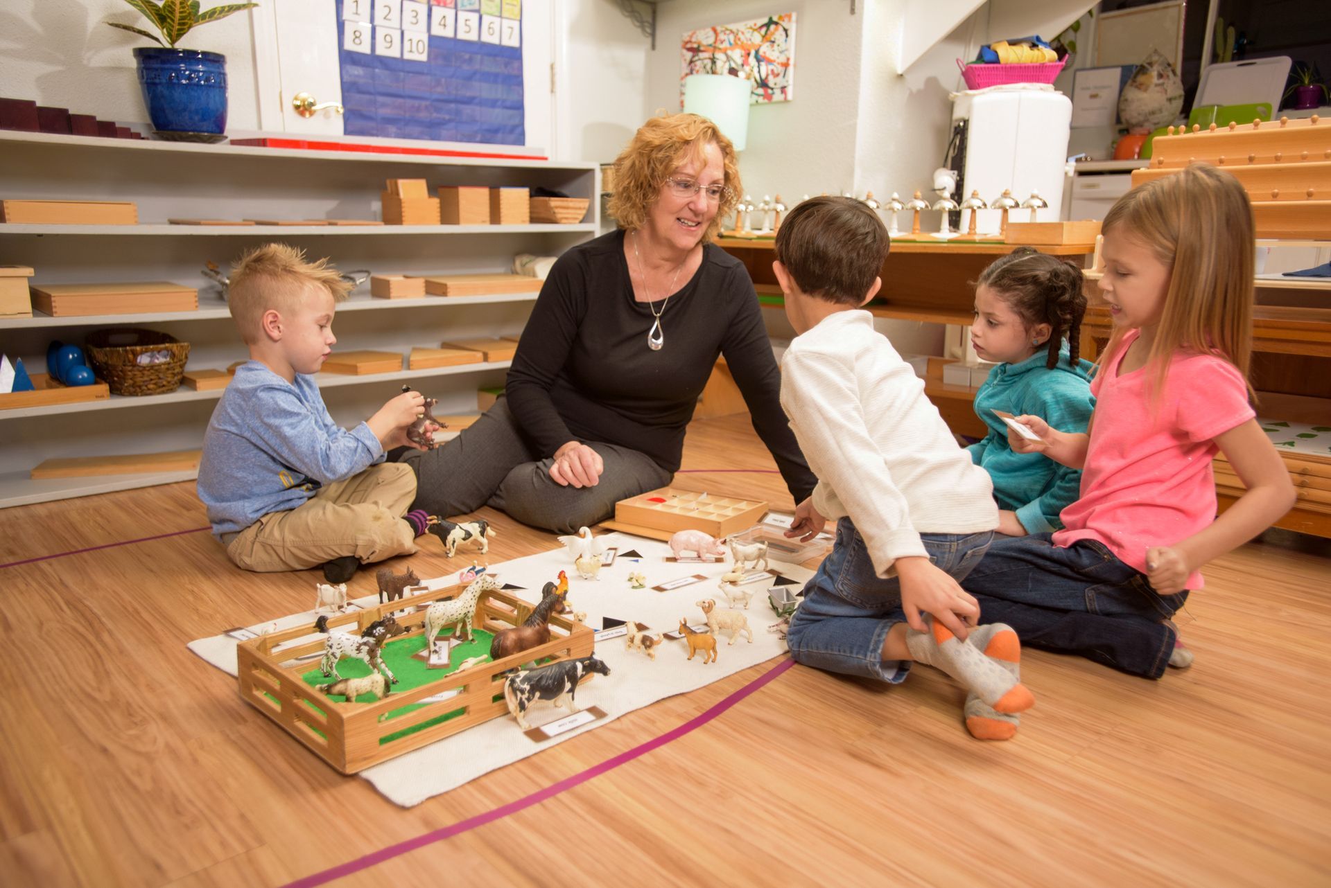 Montessori children and guide working in the classroom 