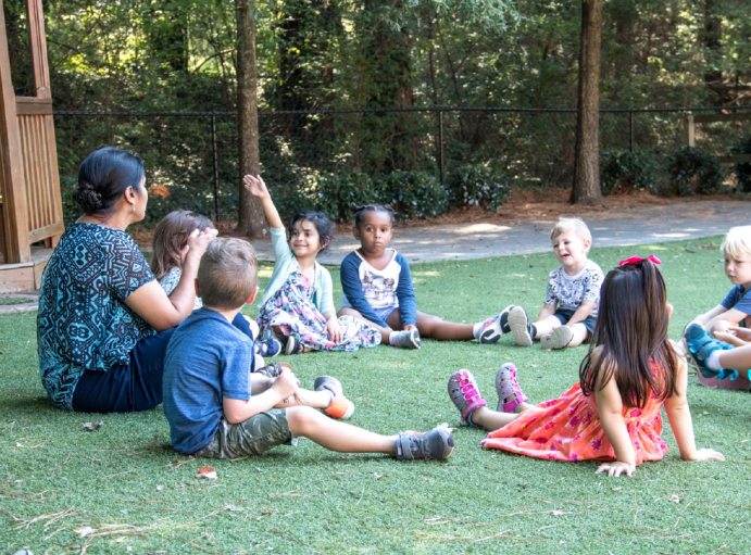 Montessori guide and children working outdoors