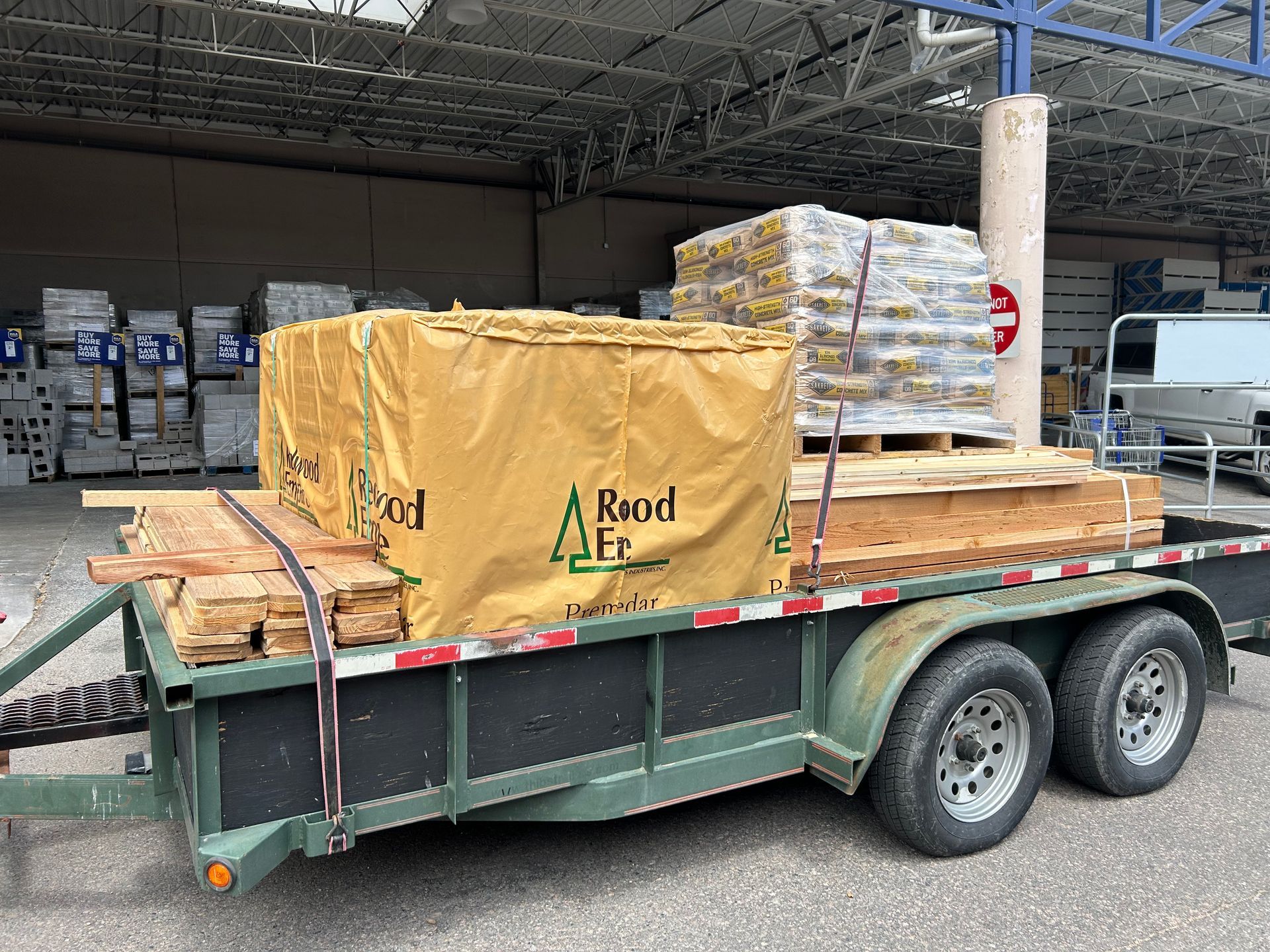 A trailer with a lot of wood on it is parked in a warehouse.