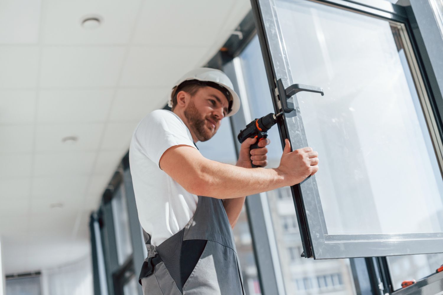 A man is installing a window on a building.