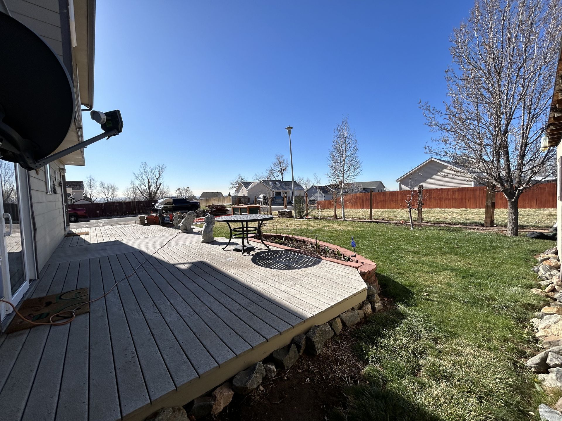 There is a large deck in the backyard of a house.