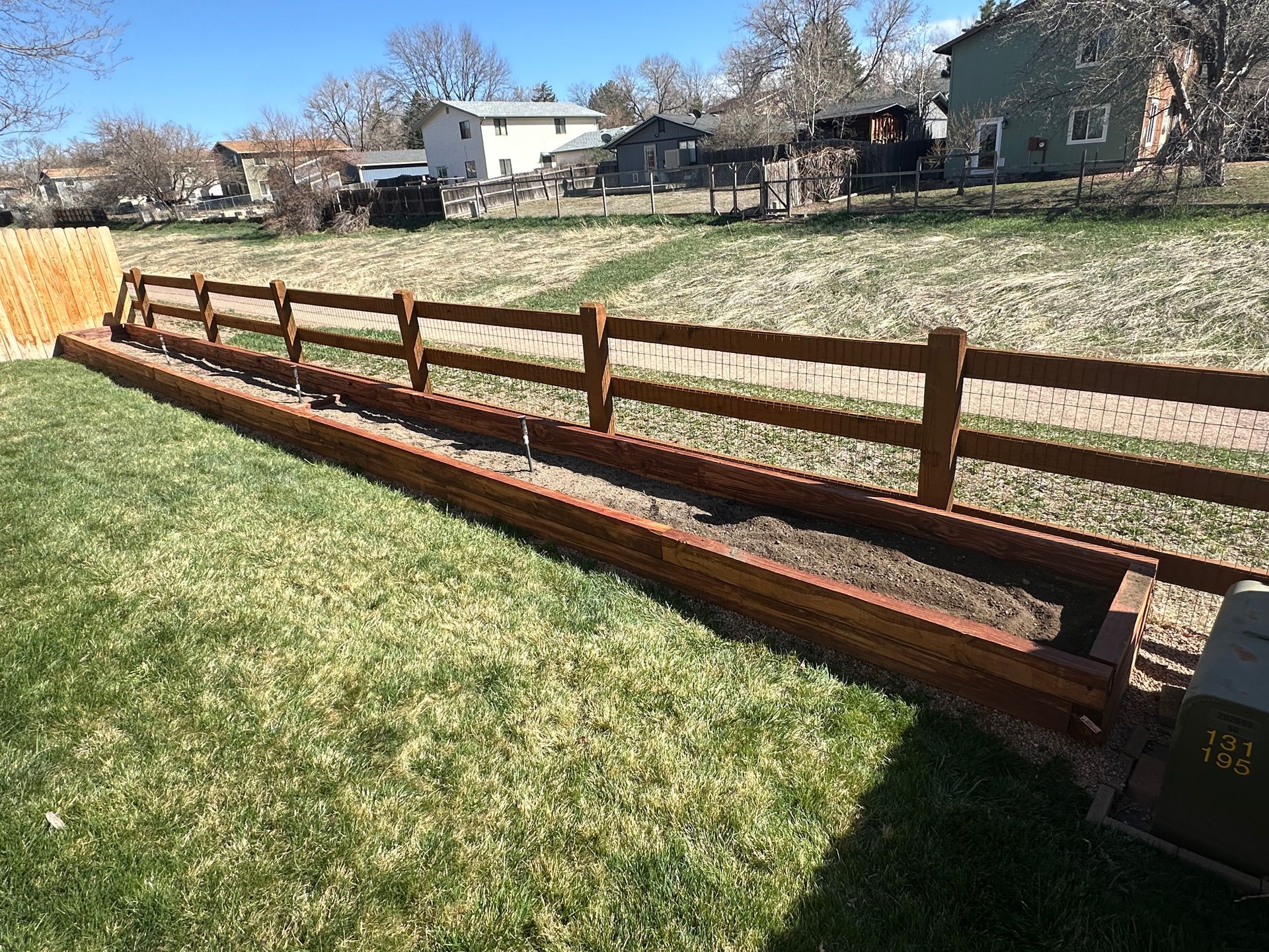 A wooden fence is sitting in the middle of a grassy field.