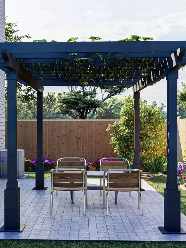 A pergola with a table and chairs underneath it in a backyard.