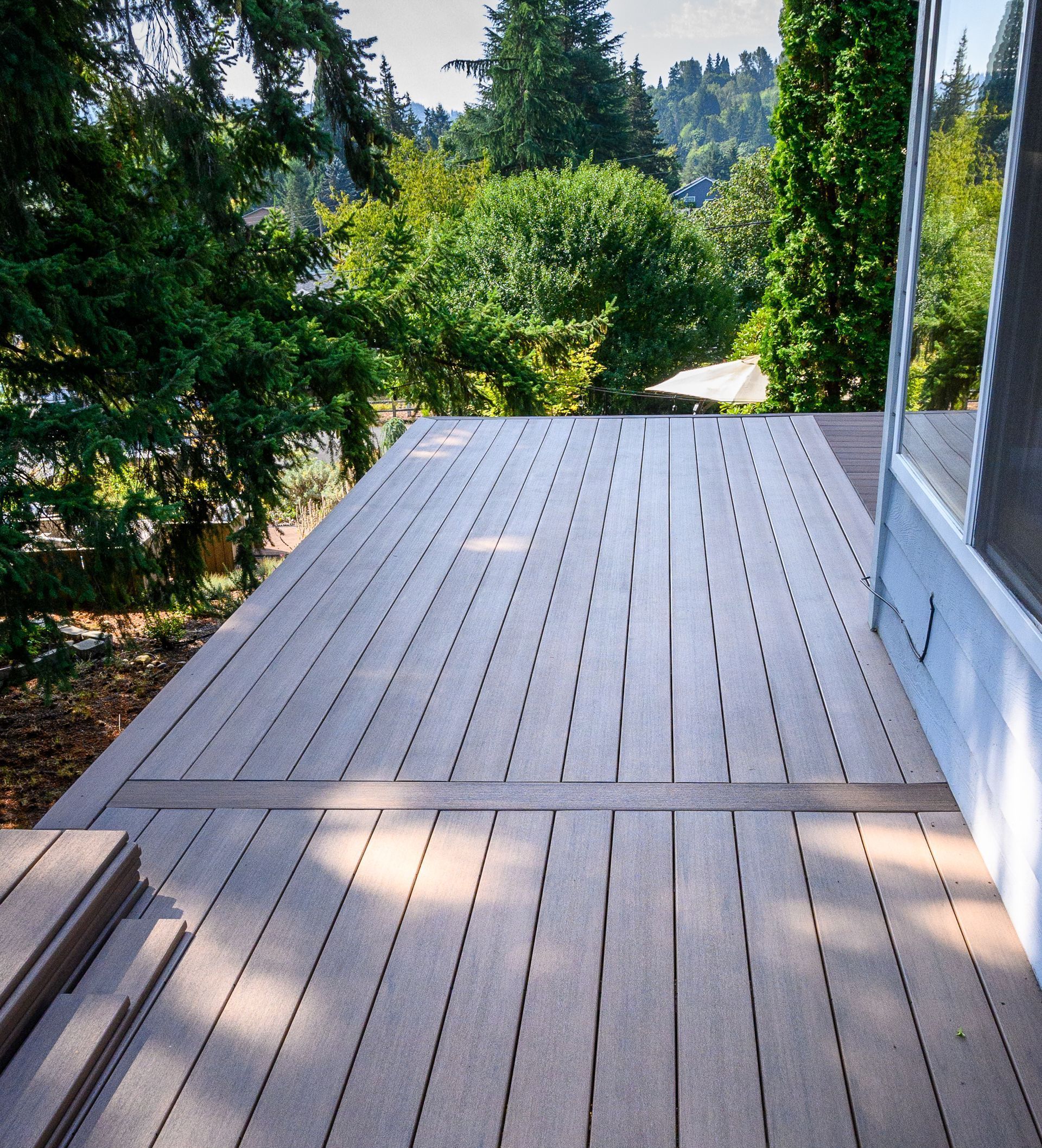 A large wooden deck with trees in the background