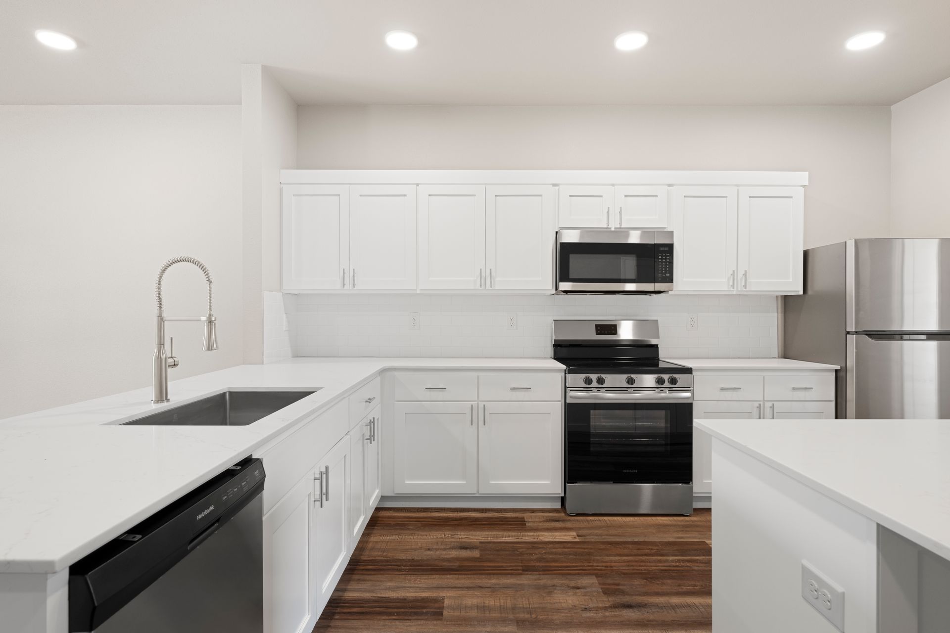A kitchen with white cabinets and stainless steel appliances