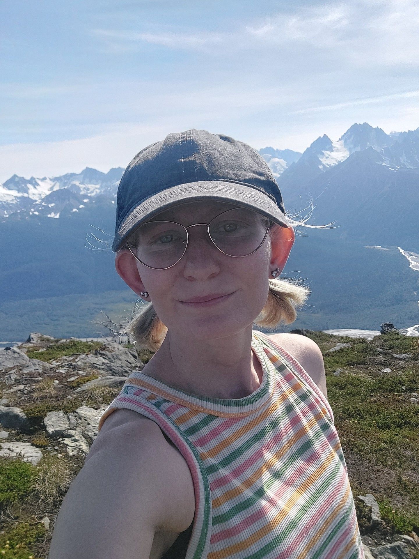 A woman wearing a hat and a jacket is smiling for the camera.