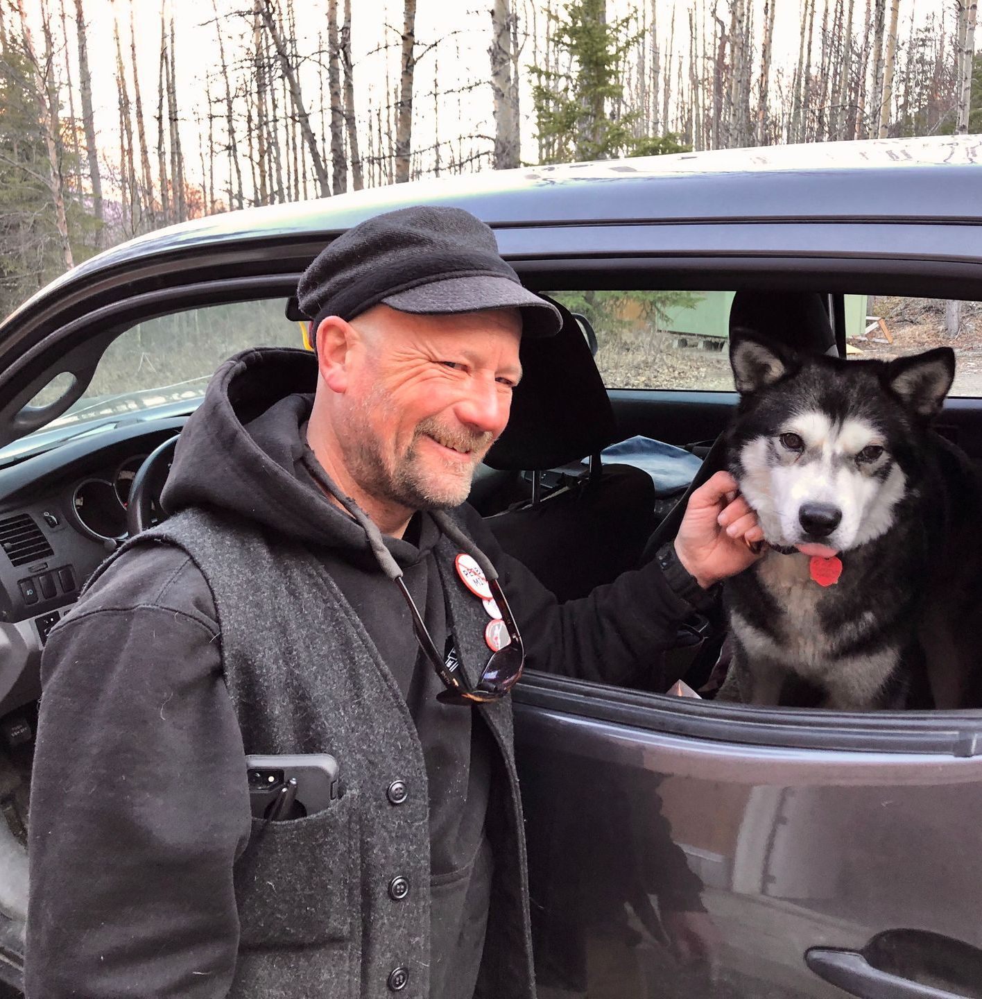 A man and a dog are sitting in a car