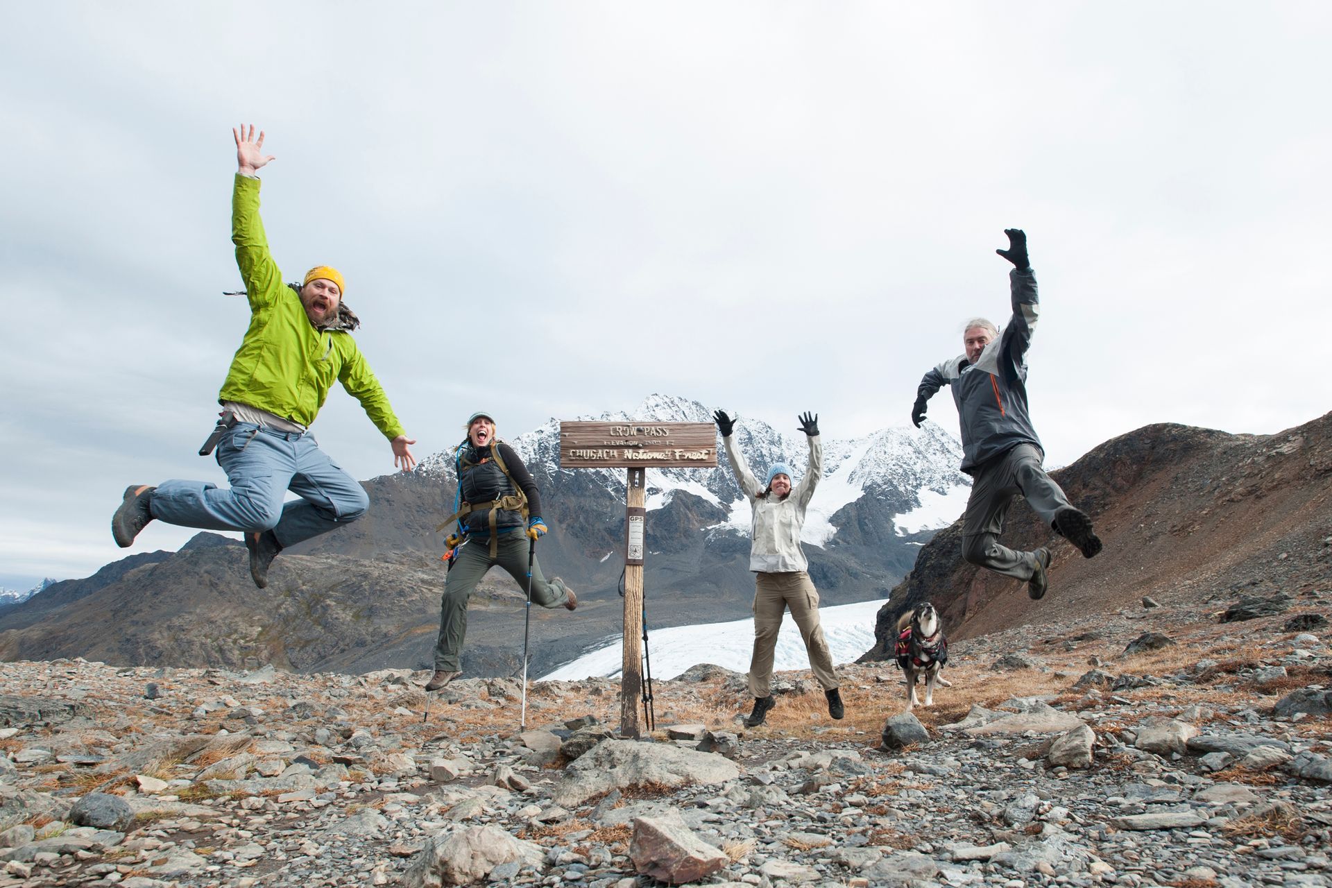 A group of people are jumping in the air in front of a sign.