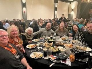 A group of people are sitting at a table with plates of food.