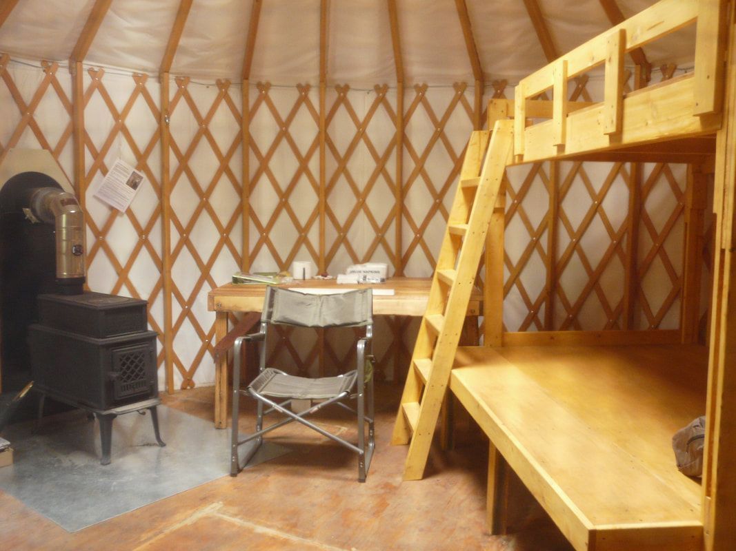 A yurt with bunk beds and a wood stove
