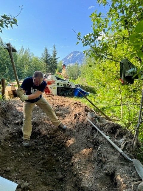 A man is digging in the dirt with a shovel