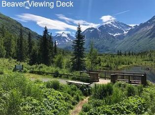 A beaver viewing deck overlooking a lake with mountains in the background.
