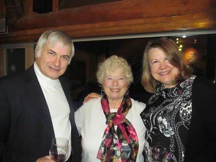 A man and two women are posing for a picture together