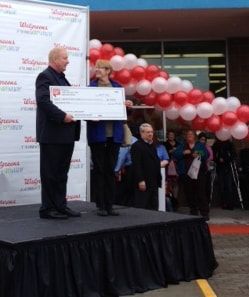A man and woman standing on a stage holding a check